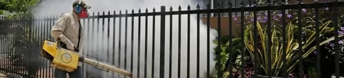 Mosquito control technician fogging a yard perimeter for mosquito reduction in Tacoma, WA